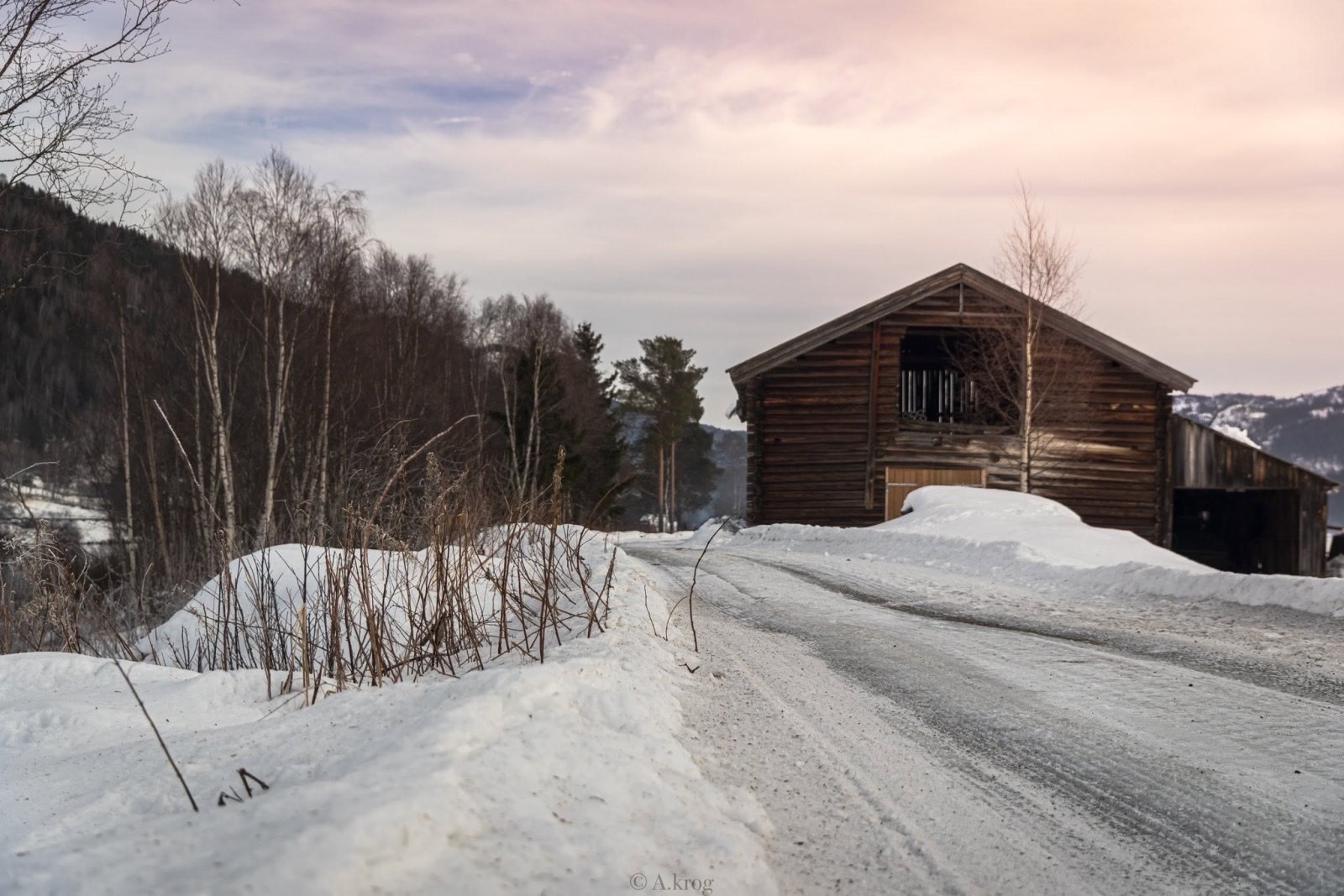 Snødekt rallytrasé ved en gammel låve.